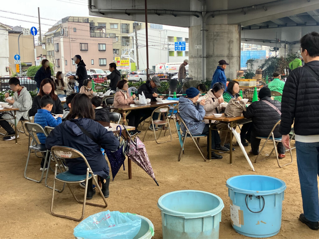 多くの地域の住民が集まり、椅子に腰かけてテーブルを囲み、つきたてのお餅を味わっていました