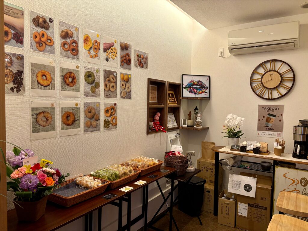 marumi kitchen donut(まるみキッチンドーナツ)さんの店内・無添加ドーナツとオリジナル焙煎コーヒーが並び、壁にはドーナツのフレーバーのラインナップの写真が飾られている